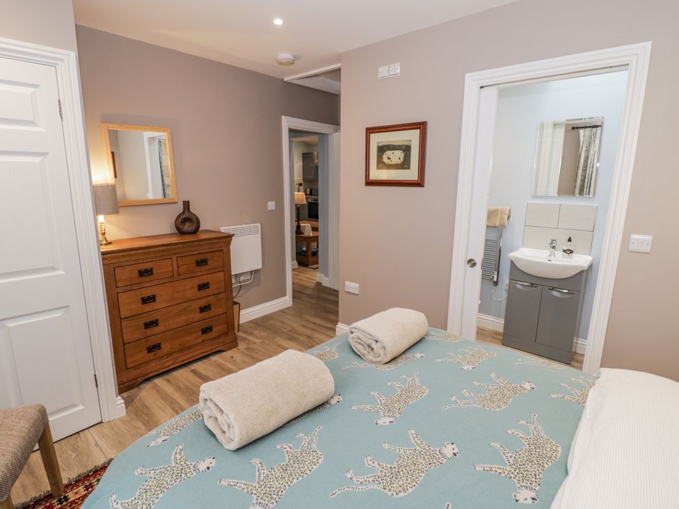 A bedroom with a bed and dresser at Lily Stables in Black Bourton near Bampton, Oxfordshire