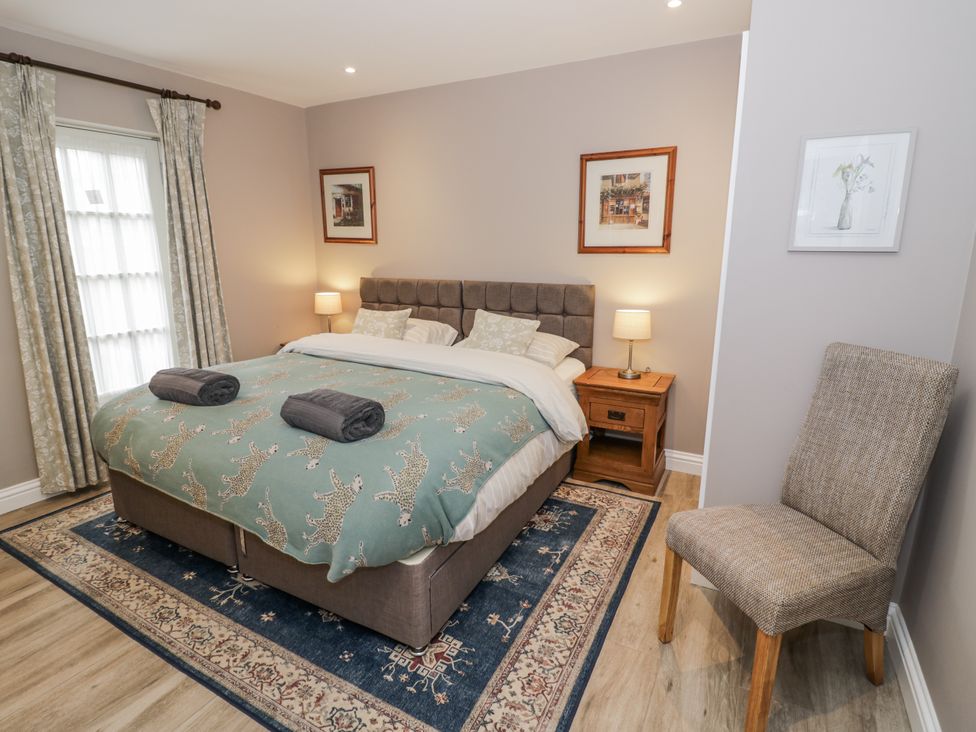 A bedroom with a bed and bedside table at Lily Stables in Black Bourton near Bampton, Oxfordshire