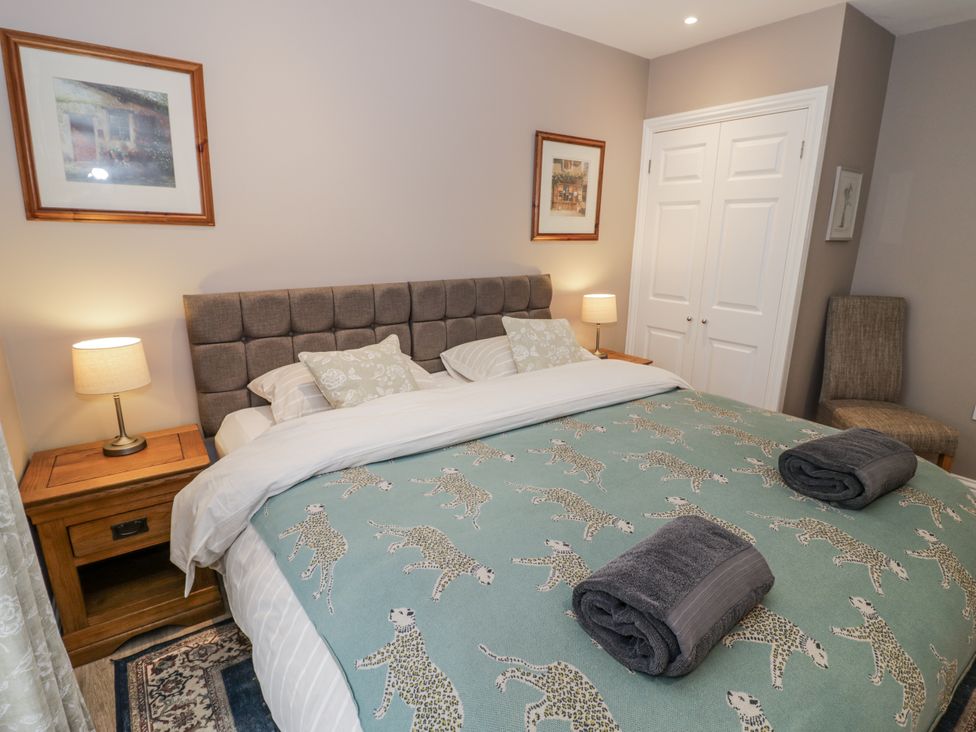 A bedroom with a double bed and bedside lamps at Lily Stables in Black Bourton near Bampton, Oxfordshire