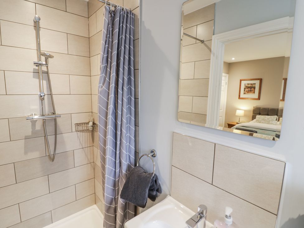 A bathroom with a shower and a mirror at Lily Stables in Black Bourton near Bampton, Oxfordshire