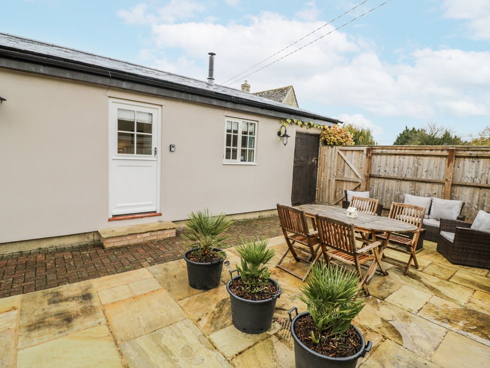 An outdoor seating area with table and chairs at Lily Stables in Black Bourton near Bampton, Oxfordshire