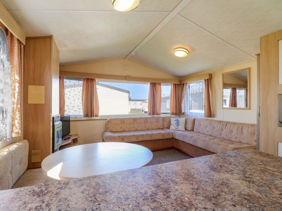 A living room with a sofa and coffee table at Luisa Family Caravan in St. Osyth