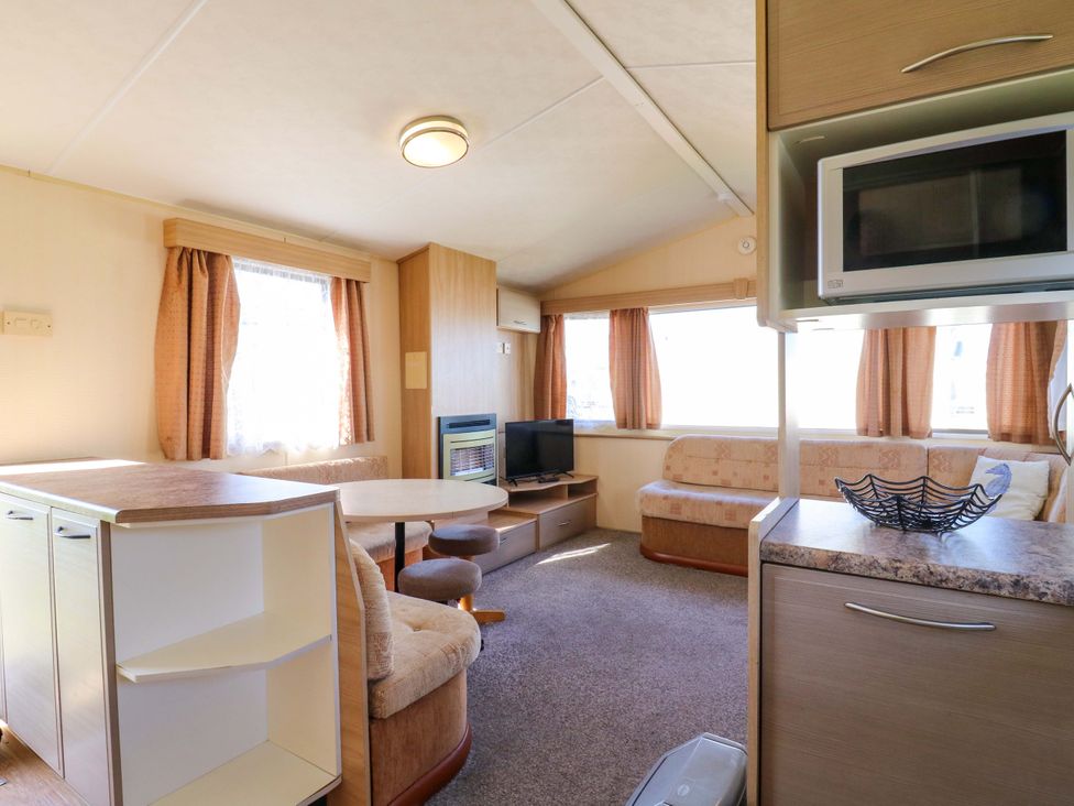 A living room with a sofa and table at Luisa Family Caravan St. Osyth