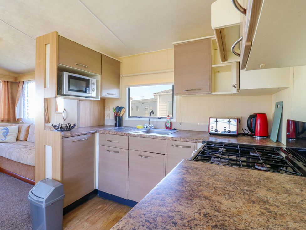 A kitchen with sink and appliances at Luisa Family Caravan St. Osyth