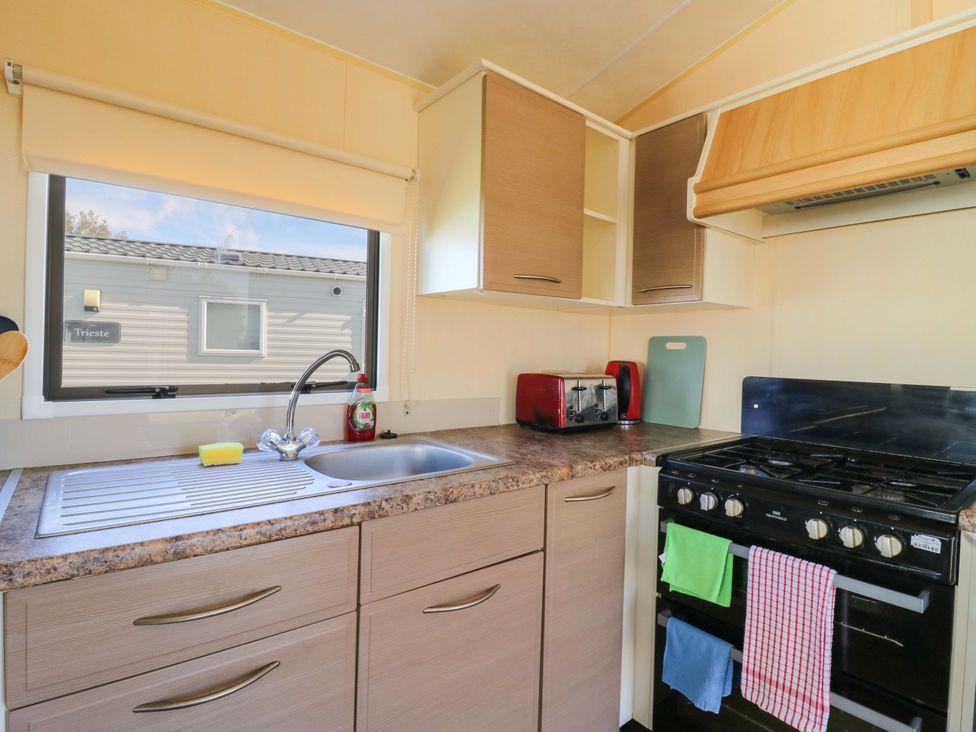 A kitchen with a sink and stove at Luisa Family Caravan in St. Osyth