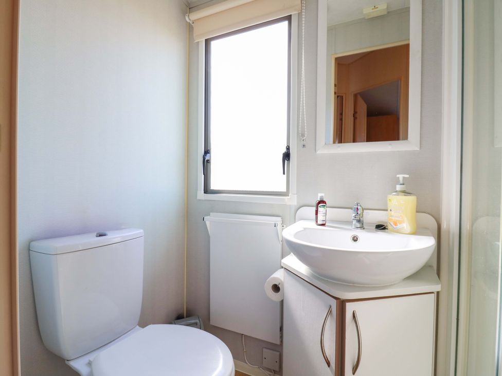 A bathroom with a toilet and sink at Luisa Family Caravan in St. Osyth