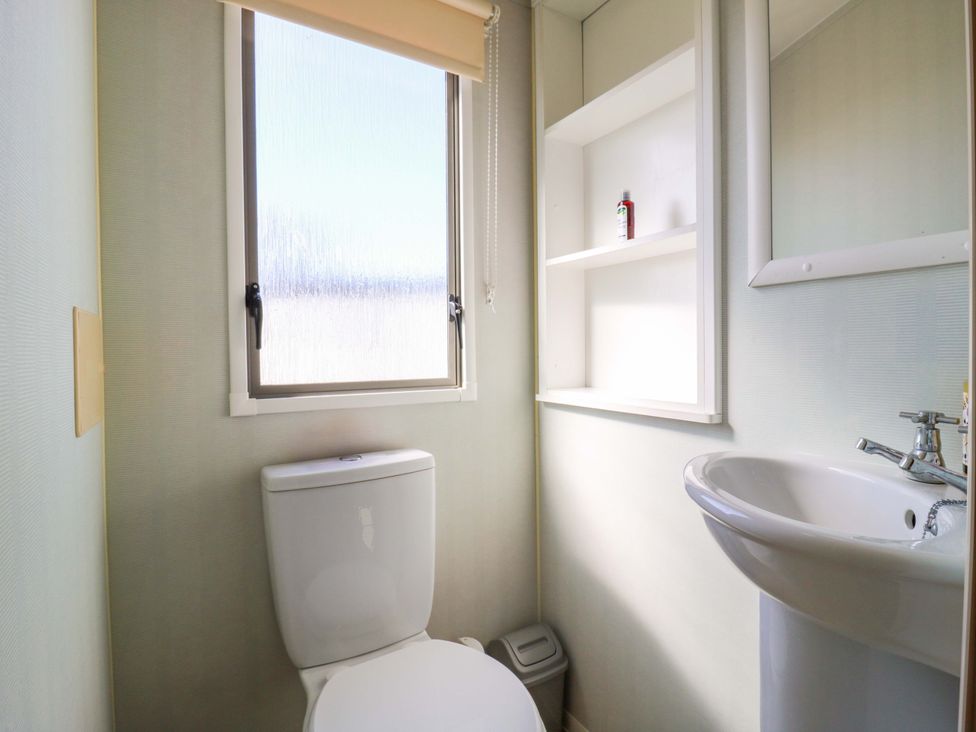 A bathroom with a toilet and sink at Luisa Family Caravan in St. Osyth