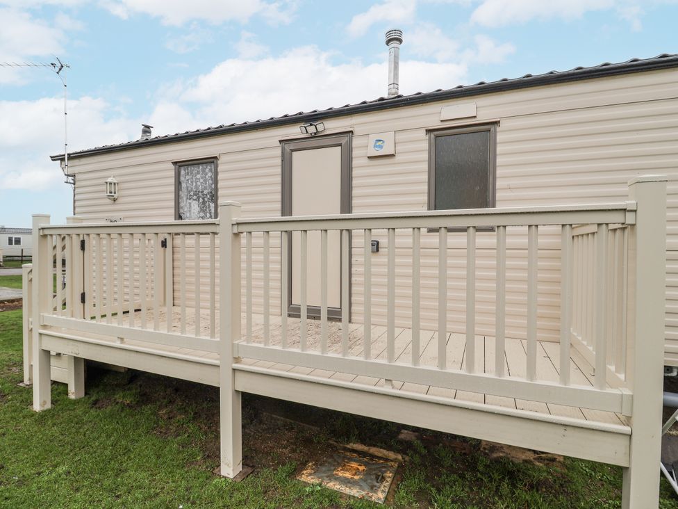 A caravan with a deck and door at Singh Leite & Luisa Family Caravan St. Osyth