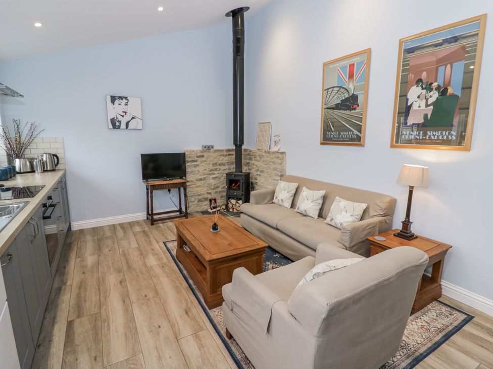 A living room with a sofa and television at Rose Stables in Black Bourton near Bampton