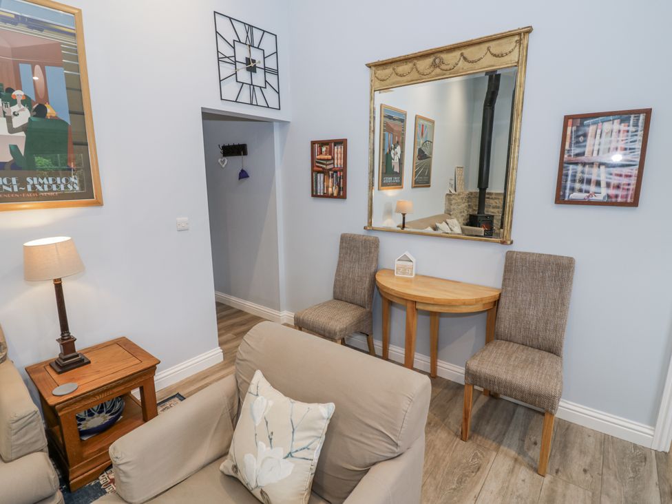 A living room with a mirror and two chairs at Rose Stables Black Bourton near Bampton