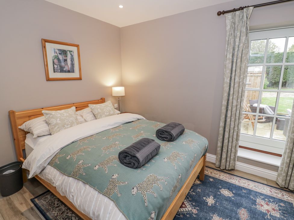 A bedroom with a bed and window at Rose Stables in Black Bourton near Bampton