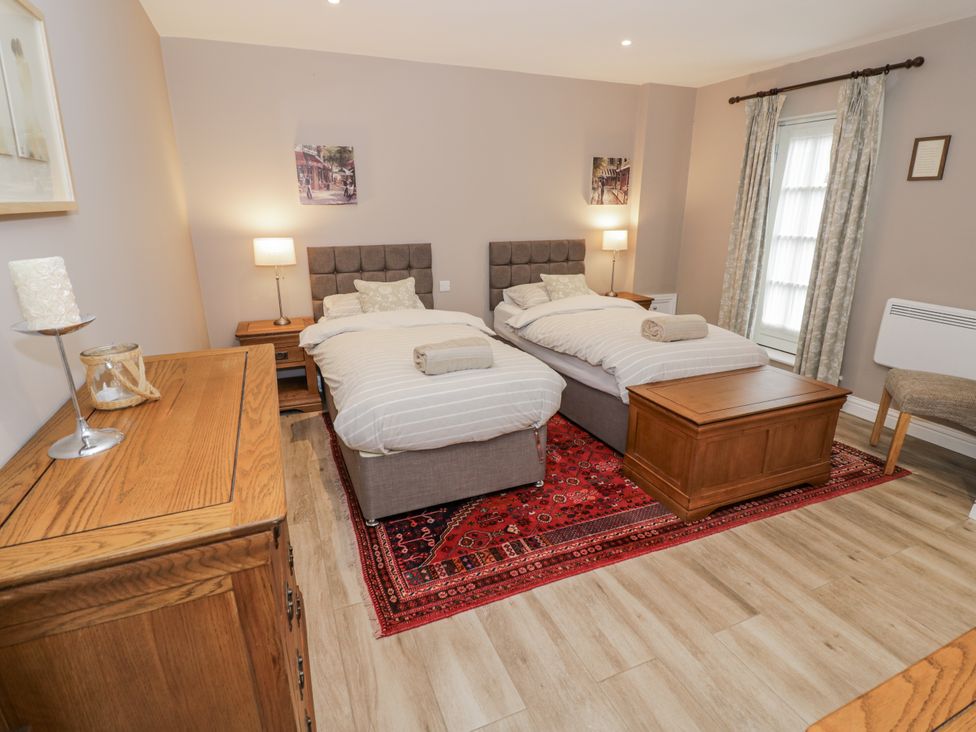 A bedroom with two single beds and a wooden chest at Rose Stables in Black Bourton near Bampton