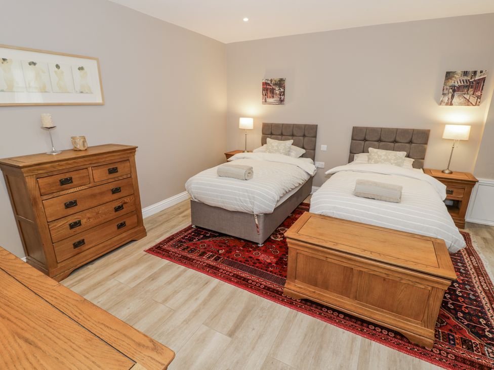 A bedroom with two beds and a dresser at Rose Stables Black Bourton near Bampton