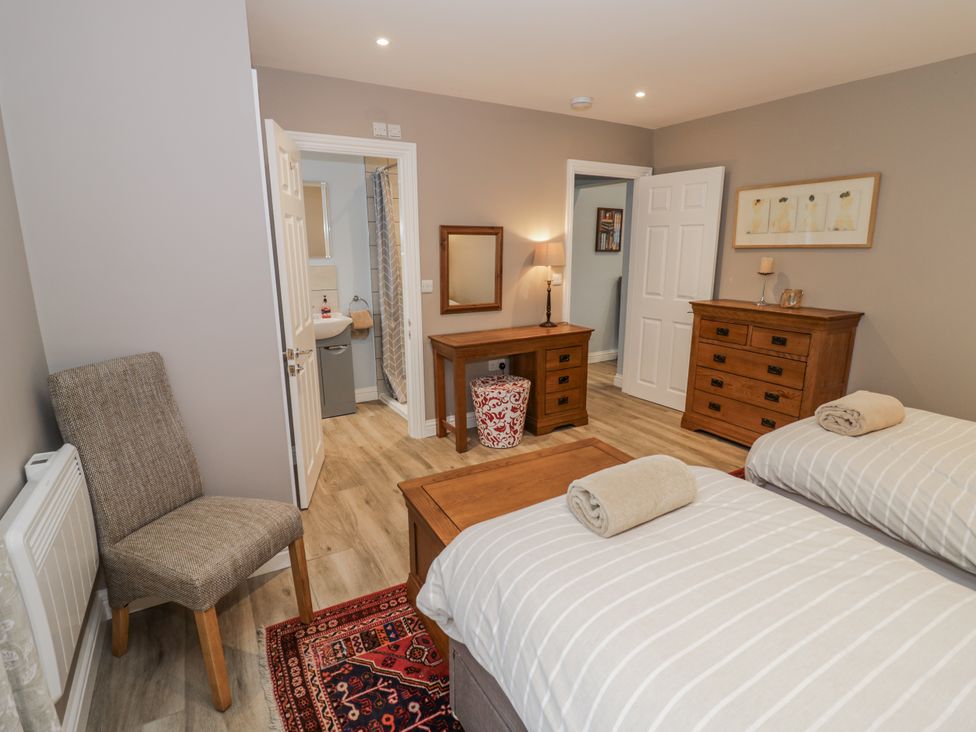 A bedroom with two beds and a dresser at Rose Stables Black Bourton near Bampton