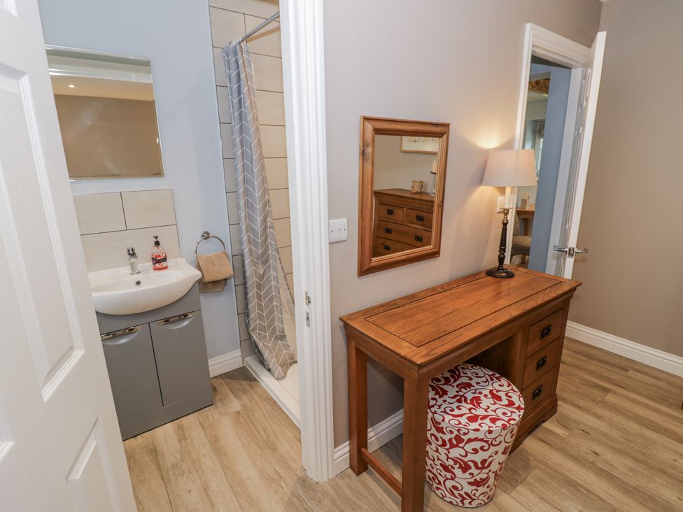 A bathroom with a shower, sink, and furniture at Rose Stables Black Bourton near Bampton