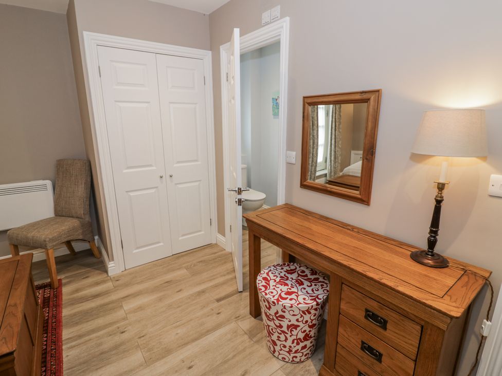 A hallway with a table a chair and a mirror at Rose Stables Black Bourton near Bampton