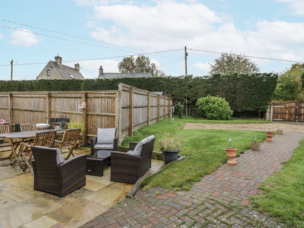 A garden with patio furniture and a dining table at Rose Stables near Black Bourton