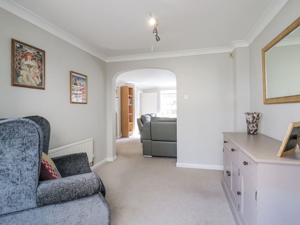 A living room with an armchair and a console table at 32 Abbey Gardens