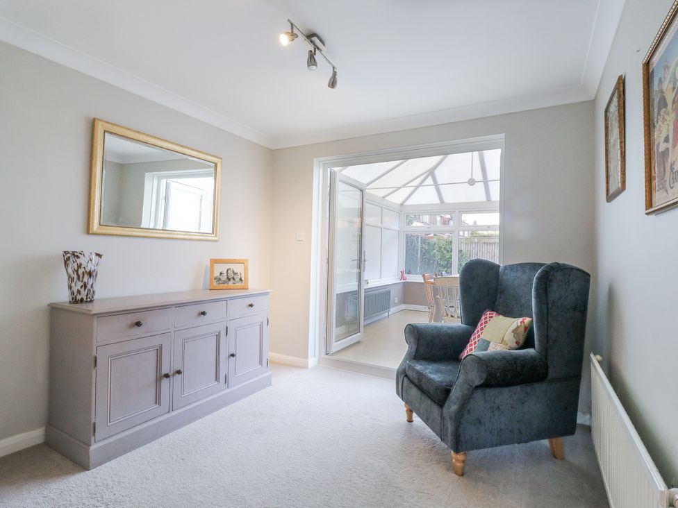 A living room with a console table and an armchair at 32 Abbey Gardens