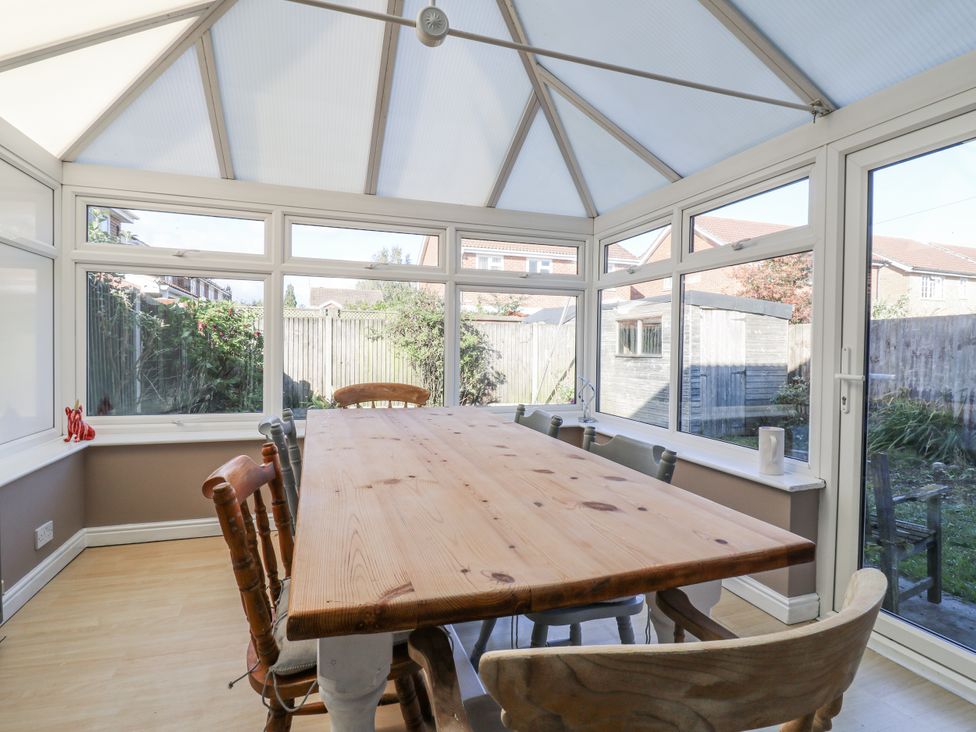 A conservatory with a large table and chairs at 32 Abbey Gardens