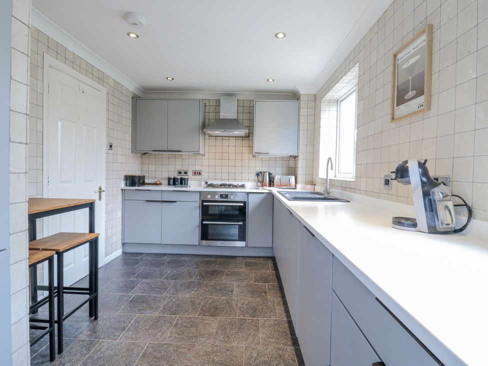 A kitchen with grey cabinets and appliances at 32 Abbey Gardens