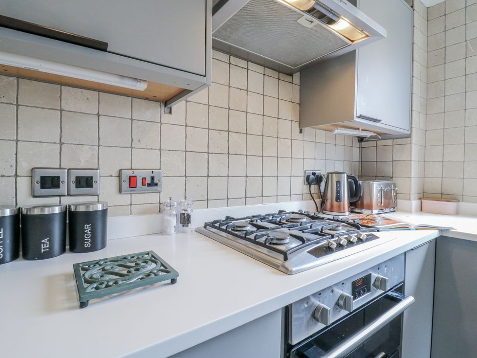A kitchen with a gas stove and countertop appliances at 32 Abbey Gardens