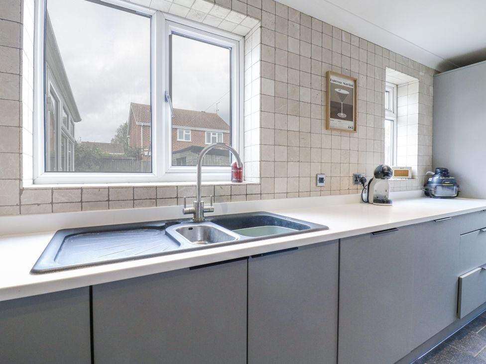 A kitchen with a sink and windows at 32 Abbey Gardens