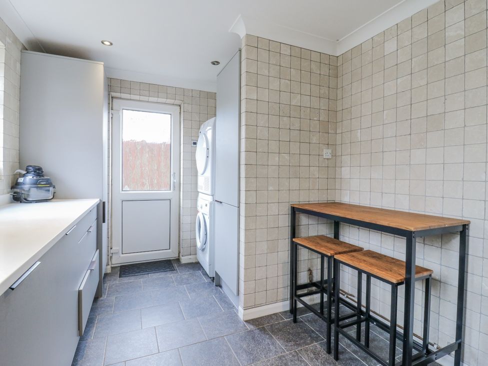 A utility room with a countertop and washing machine at 32 Abbey Gardens