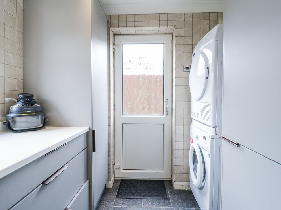 A laundry room with a washing machine and dryer at 32 Abbey Gardens