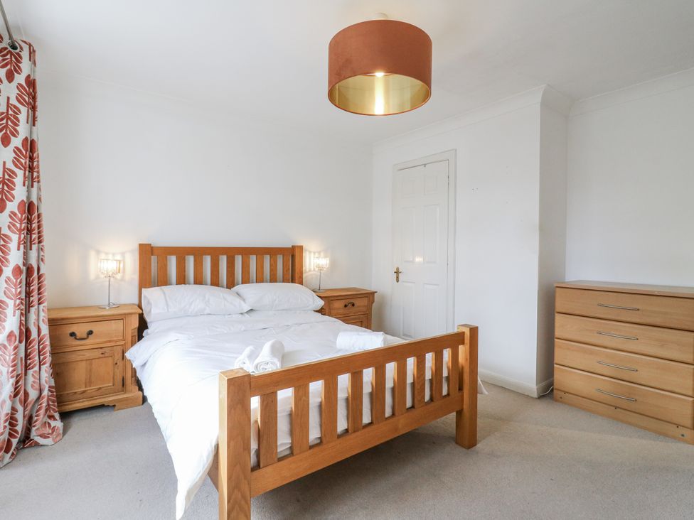 A bedroom with a bed and bedside tables at 32 Abbey Gardens