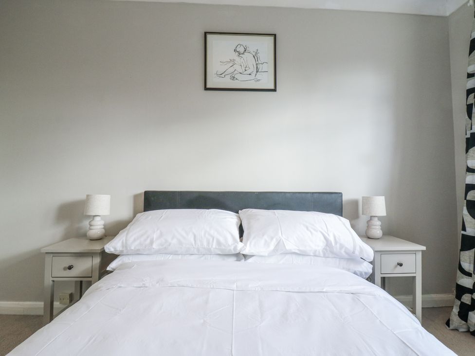 A bedroom with a bed and bedside tables at 32 Abbey Gardens