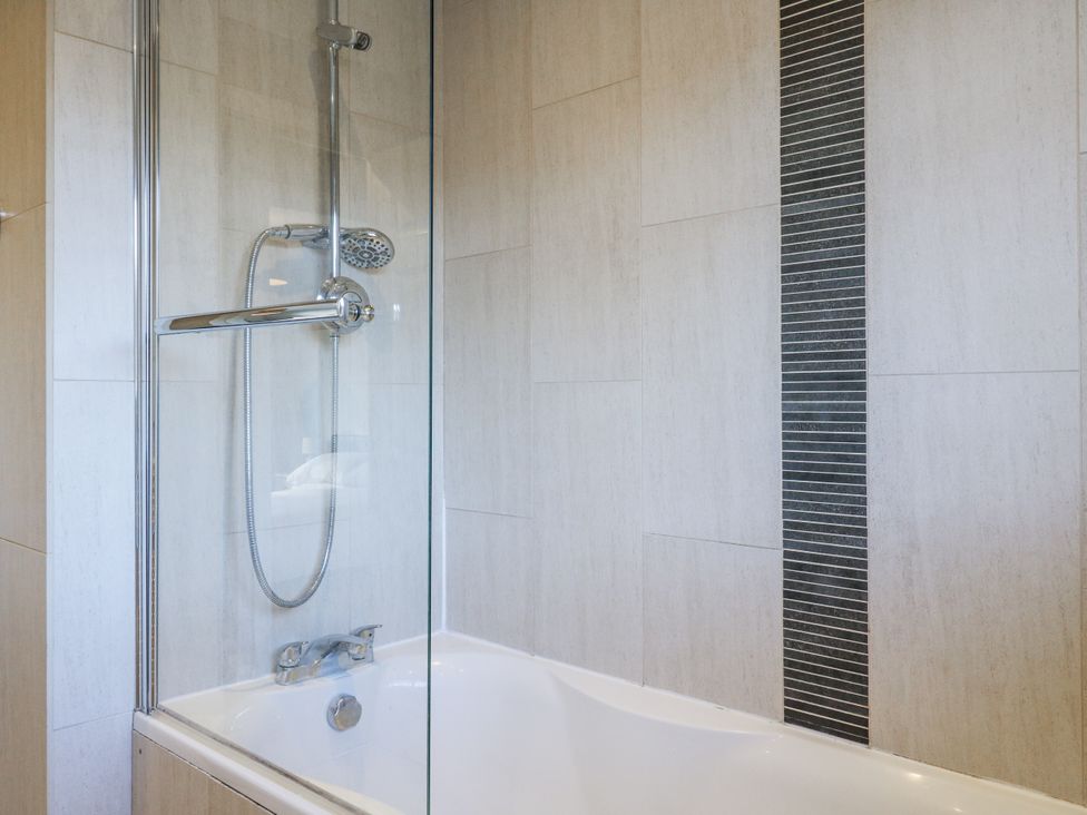 A shower over a bath in a bathroom at 32 Abbey Gardens
