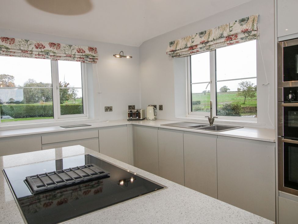 A kitchen with a sink and appliances at Garden Cottage in Ellesmere
