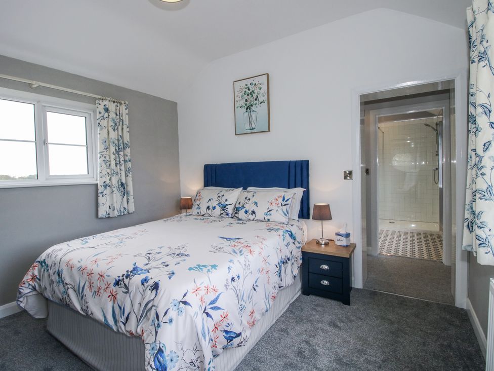 A bedroom with a bed and shower access at Garden Cottage in Ellesmere