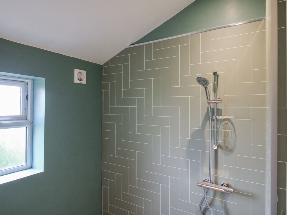 A bathroom with a shower and window at Garden Cottage in Ellesmere