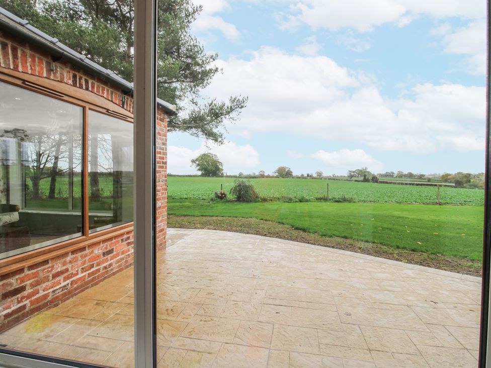 An outdoor patio area with a view of fields at Garden Cottage in Ellesmere