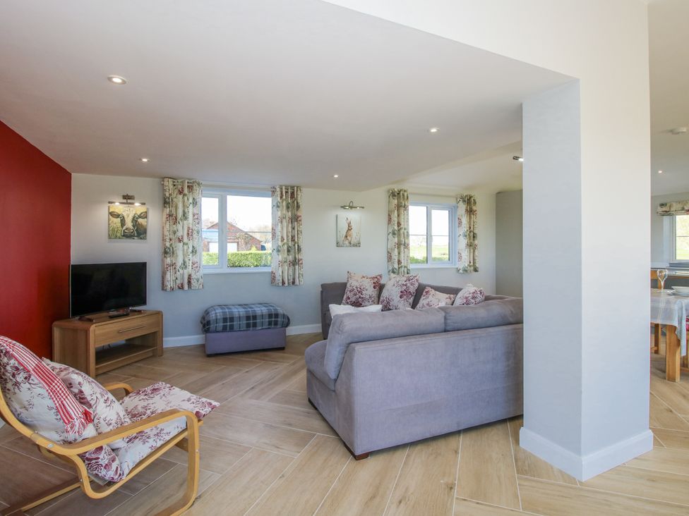A living room with a sofa and television at Garden Cottage in Cockshutt