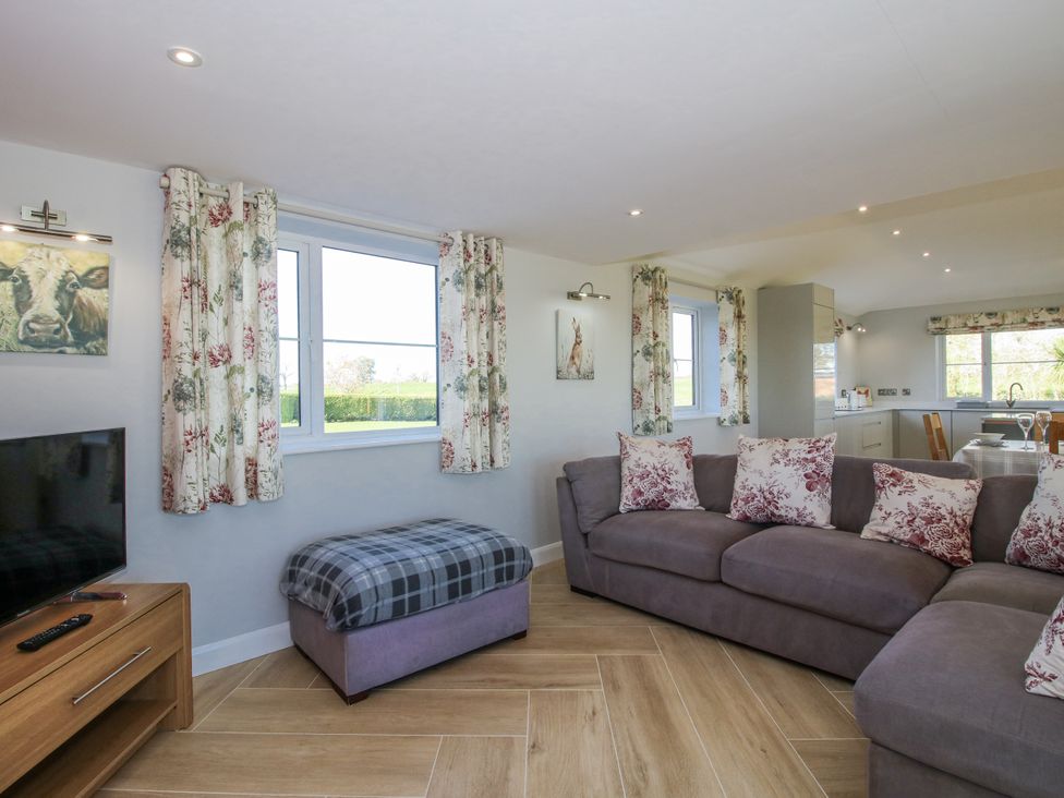 A living room with a sofa and television at Garden Cottage in Cockshutt