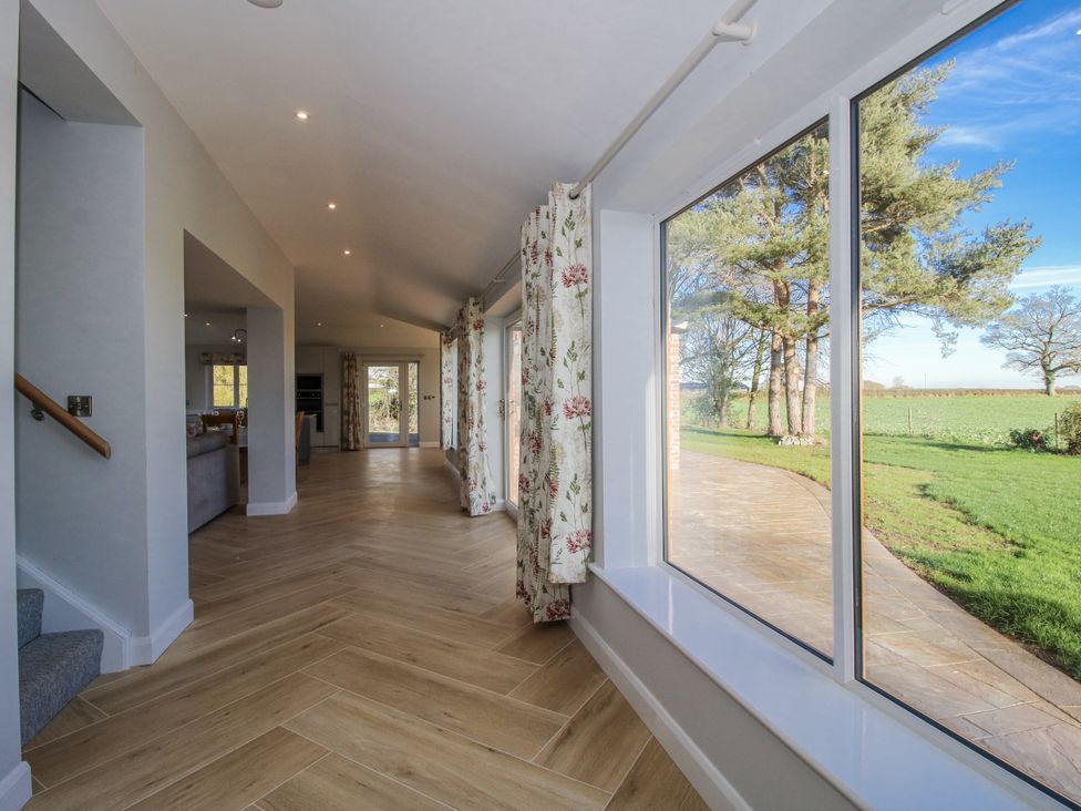 A hallway with windows and curtains at Garden Cottage in Cockshutt
