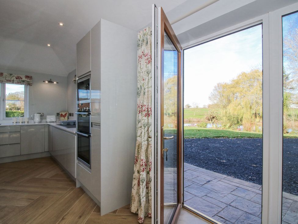 A kitchen with a door open to a garden at Garden Cottage in Cockshutt