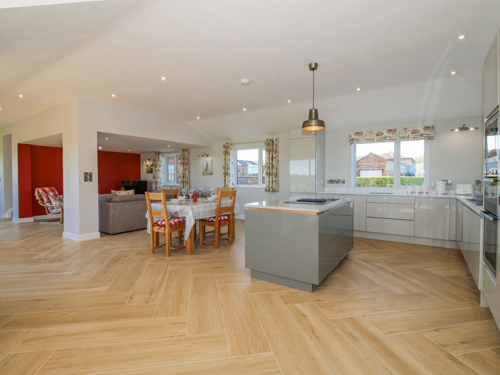 A kitchen with table and chairs and a sofa at Garden Cottage in Cockshutt