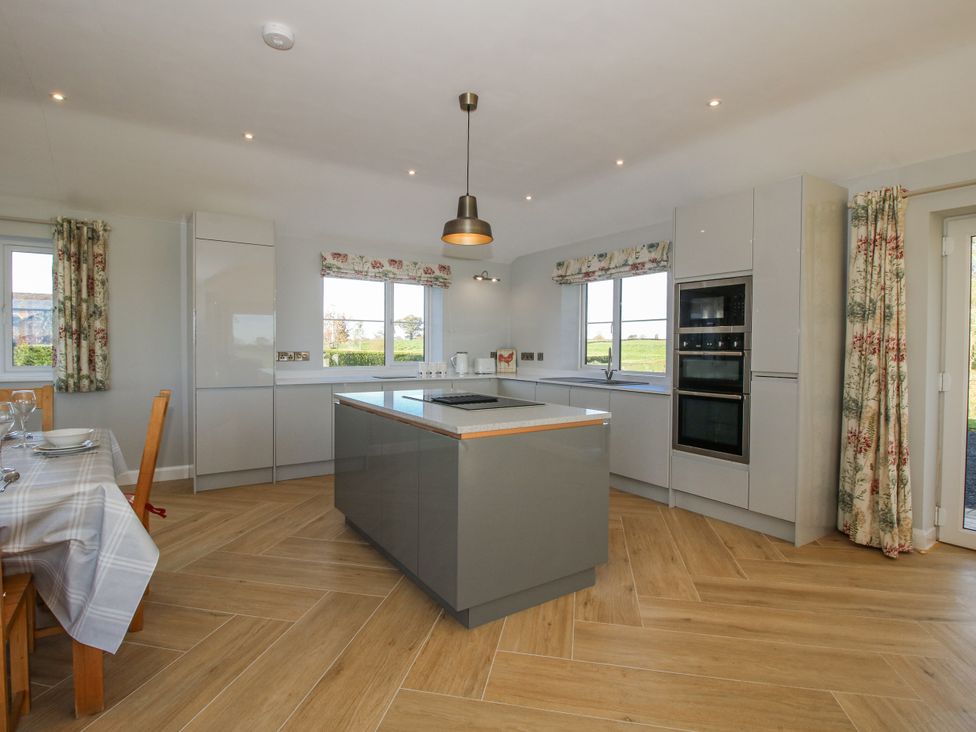 A kitchen with cabinets and an island at Garden Cottage in Cockshutt