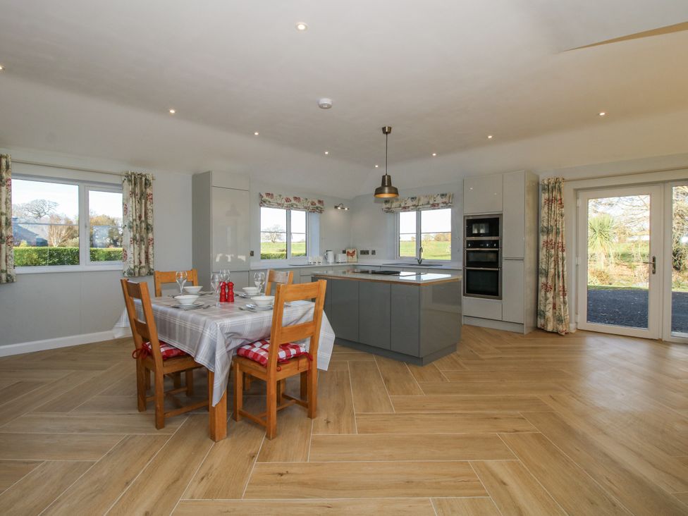 A kitchen with a dining table and kitchen island at Garden Cottage Cockshutt