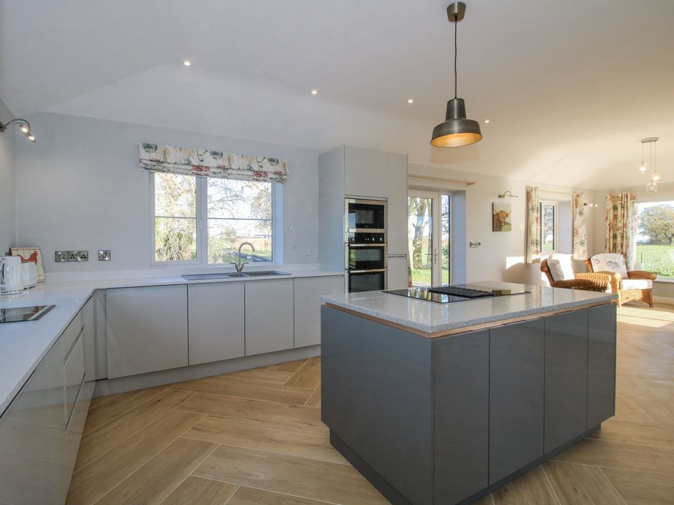 A kitchen with modern appliances and a large island at Garden Cottage in Cockshutt