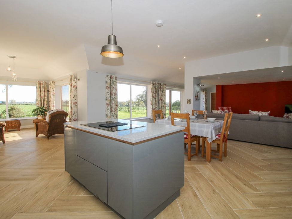 A kitchen with a dining table and sofa at Garden Cottage in Cockshutt