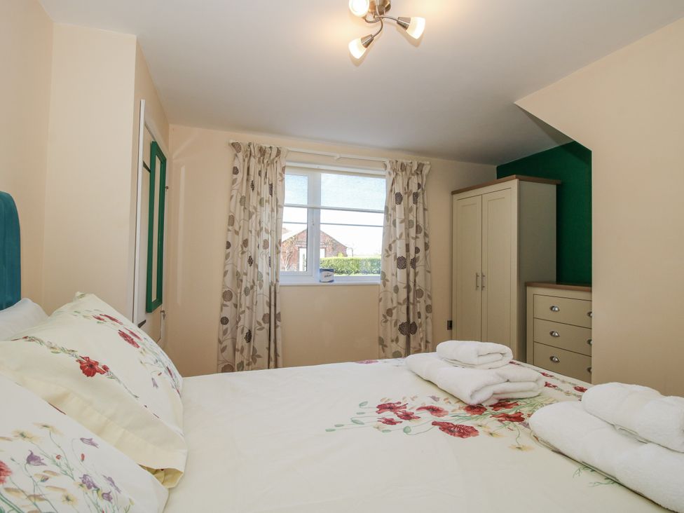 A bedroom with a bed and wardrobe at Garden Cottage in Cockshutt