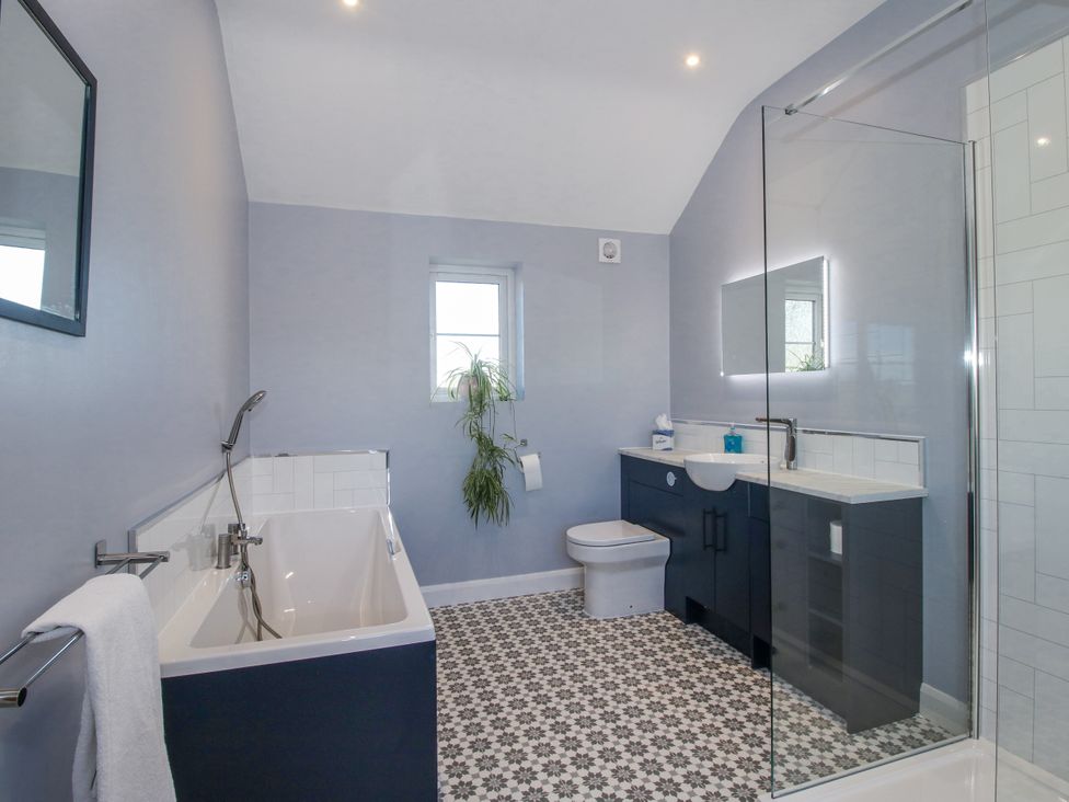 A bathroom with bathtub, toilet, sink, and shower at Garden Cottage in Cockshutt