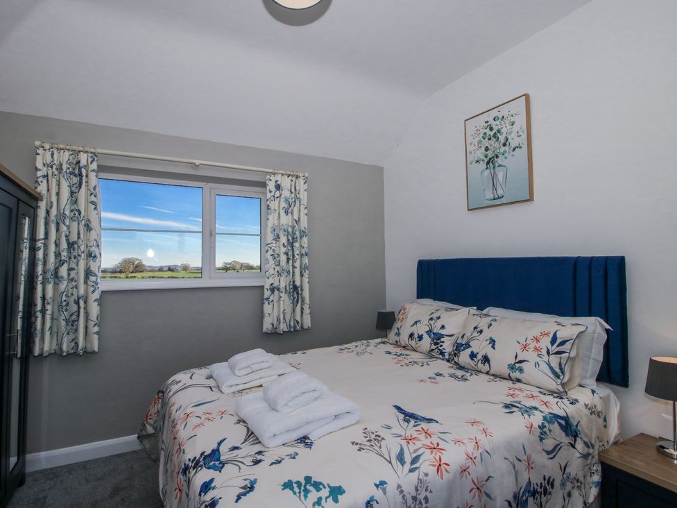 A bedroom with a bed and a window at Garden Cottage in Cockshutt