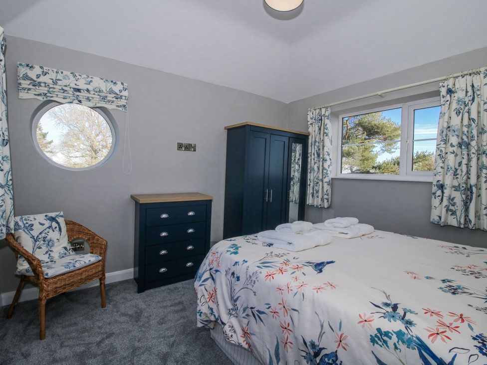A bedroom with a bed and wardrobe at Garden Cottage in Cockshutt