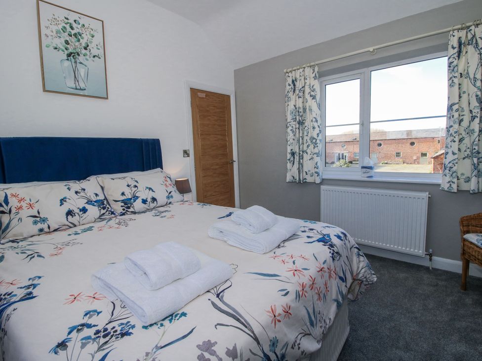 A bedroom with a bed and window at Garden Cottage in Cockshutt